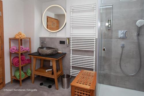 La salle de bains est pourvue d'une douche, d'un lavabo et d'un miroir. dans l'établissement das Alpen Natur Idyll, à Grainau