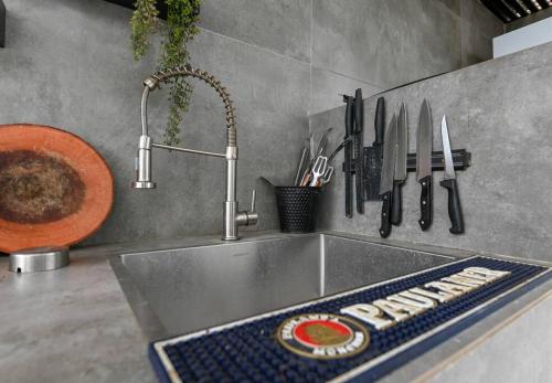 eine Küchentheke mit Spüle und Messern darauf in der Unterkunft וילה לה וידה in Migdal