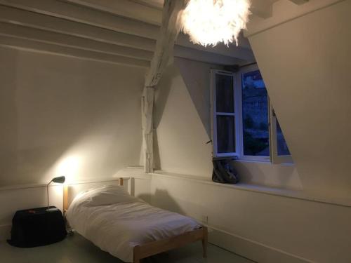 - une petite chambre avec un lit et une fenêtre dans l'établissement Grande Maison à Semur en plein coeur Historique, à Semur-en-Auxois