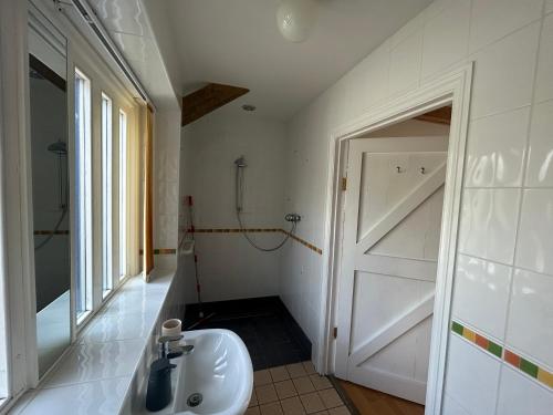baño con lavabo blanco y puerta en Wheal Hart en Newlyn East