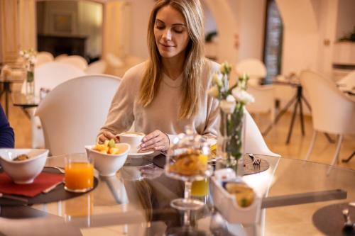 a woman sitting at a table with a bowl of fruit at RELAIS CASCINA ERA in Sandigliano