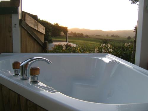 bañera blanca con vistas a un campo en Memory Lane Country Cottage en Cambridge