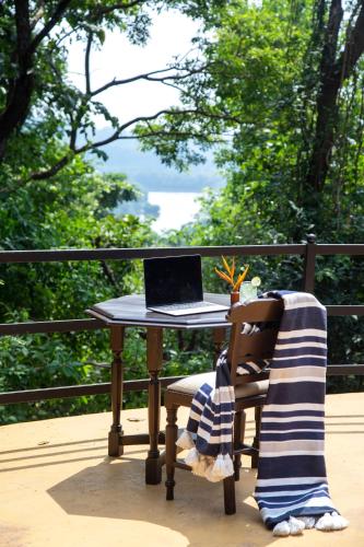 a table with a laptop computer on it next to a chair at Wildflower Villas - All Villa Hotel, Family Run in Candolim