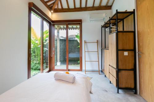 1 dormitorio con cama y ventana grande en Singgah di Ubud 2 en Ubud