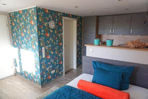 um quarto com uma cama e uma cozinha com uma parede em Burghaus 2 em Greetsiel
