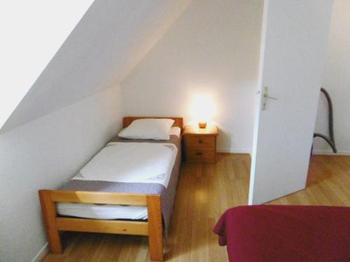 une petite chambre avec un lit et une table de chevet dans l'établissement Maisonnette 3 pièces 5 personnes à 200 m de la plage - MIKAEL, à Sarzeau