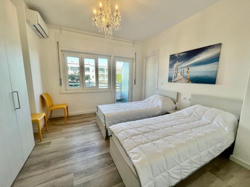 a bedroom with two beds and a chandelier at Condominio Martini in Grado