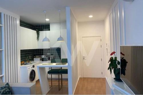 a kitchen with a sink and a table in a room at Casa Moliceiro Verde in Aveiro