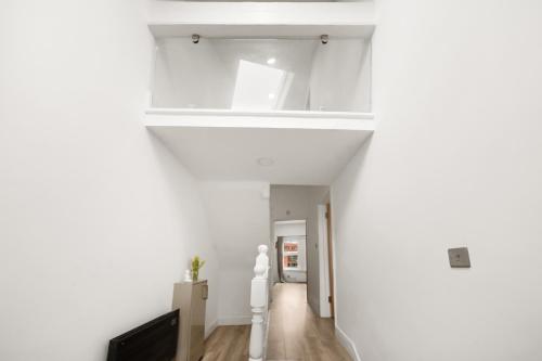 a hallway with white walls and a white ceiling at 3BR Duplex Penthouse Harrow centre in Harrow