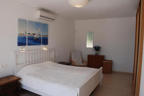 een slaapkamer met een groot wit bed en een stoel bij Casa Calahonda in Sitio de Calahonda