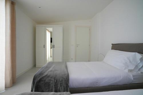 a bedroom with a bed with white sheets and a window at Keys of Sicily - Appartamenti Modica Bassa in Modica