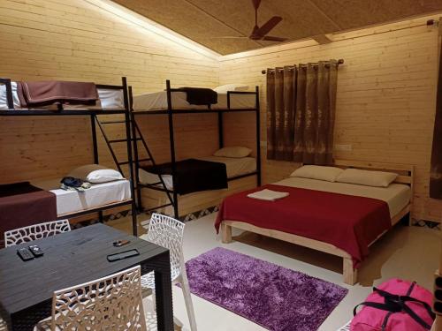 a room with two bunk beds and a table and chairs at Kodai Elegance in Kodaikānāl
