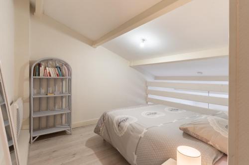 um quarto com uma cama e uma estante de livros em COSY Home - 2 à 4 pers - Aéroport - vieux Blagnac em Blagnac