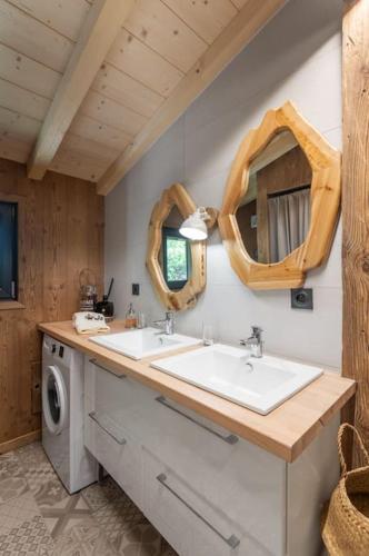 une salle de bain avec deux lavabos et deux miroirs dans l'établissement Charmant chalet cosy & paisible en pleine nature - refuge idyllique pour 5p, à Gérardmer