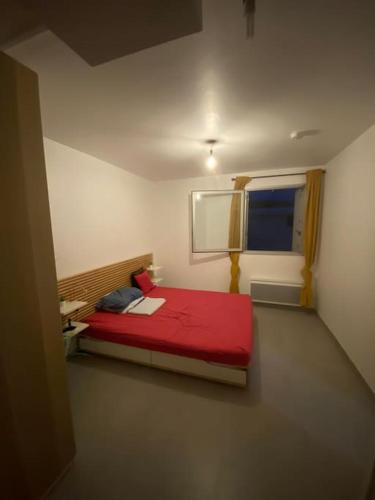 - une chambre avec un lit rouge et une fenêtre dans l'établissement Bel Appartement 1 chambre à 50m de la plage, à Sète