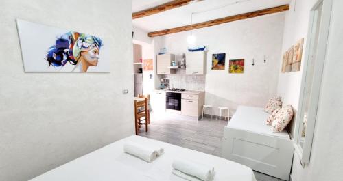 a white apartment with a kitchen and a living room at Eremo sul Mare in Marina di Fuscaldo