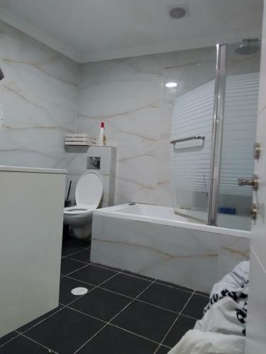 ein weißes Bad mit einer Badewanne und einem WC in der Unterkunft צימר מפואר שבתות וחגים in Bet Schemesch