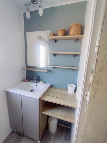 une salle de bain avec un lavabo et un miroir dans l'établissement Mobil home 40 m2 camping 4*, à Valras-Plage