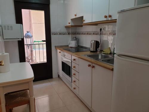 una cucina con frigorifero bianco e lavandino di Apartamento Ángel en Palma a Benidorm