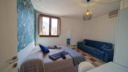 a bedroom with a bed and a blue couch at Destiny Home 7 Verona Fiera in Verona