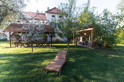 a park with a wooden bench in the grass at Schlossgut Gundersdorf in Klagenfurt