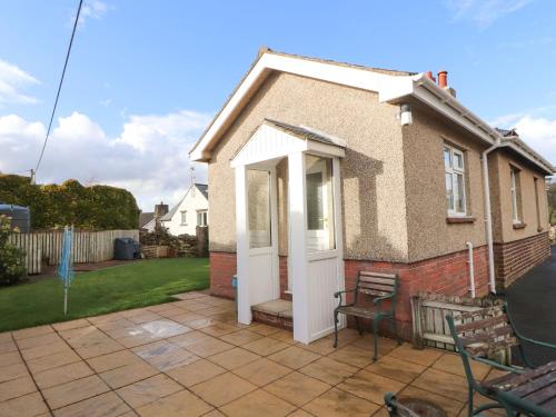 a small house with a white door on a patio at Eusebank in Pooley Bridge