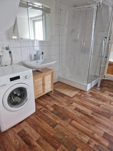 een badkamer met een wasmachine en een douche bij Tilly Apartment in Hannoversch Münden
