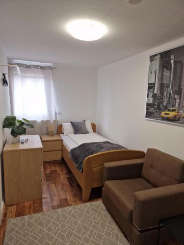 een slaapkamer met een bed, een bank en een stoel bij Tilly Apartment in Hannoversch Münden