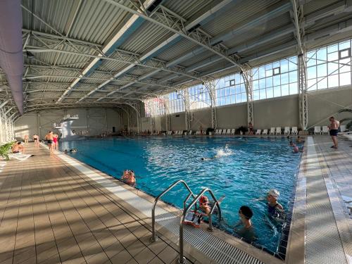 a large indoor swimming pool with people in it at Hotel Alinalex - Paradisul Acvatic in Braşov