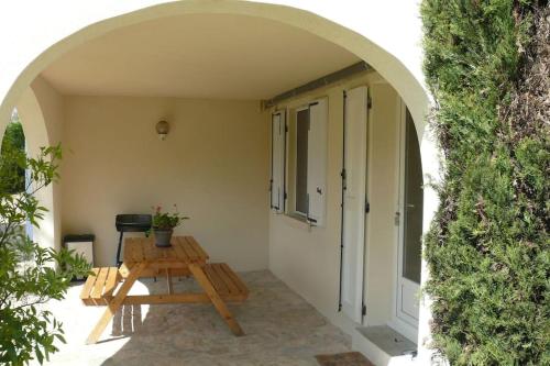 an archway with a wooden picnic table in a courtyard at Gîte et chambre d'hôtes Chez Marie in Compeyre