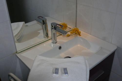 lavabo con toalla blanca y grifo en Gîte et chambre d'hôtes Chez Marie, en Compeyre
