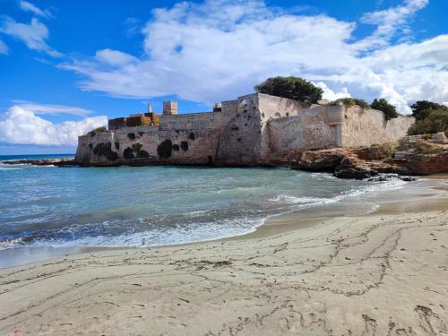an old castle on the shore of a beach at Masseria Verbena Agriturismo in Monopoli