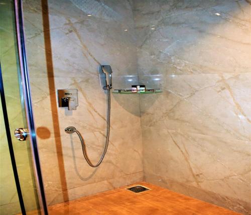 a shower with a glass door in a bathroom at Kumbhal Exotica Resort Kumbhalgarh in Kumbhalgarh