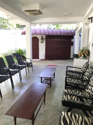 a lobby with chairs and tables and a garage at Duvi's Shelter Bungalow in Colombo