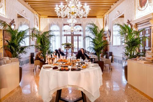 un comedor con una mesa con comida. en Palazzo Keller, en Venecia