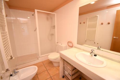 a bathroom with a sink and a toilet and a mirror at Apartamento La Senia in Jávea