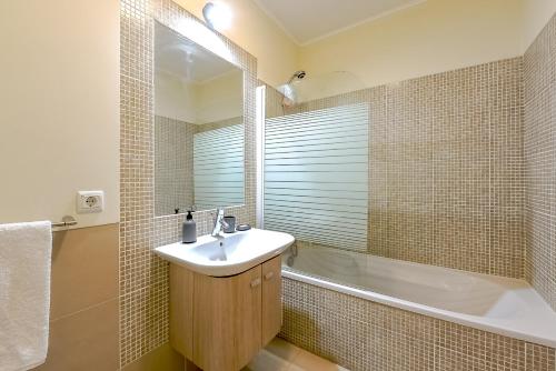a bathroom with a sink and a bath tub at Penthouse Papoila in Cabanas de Tavira
