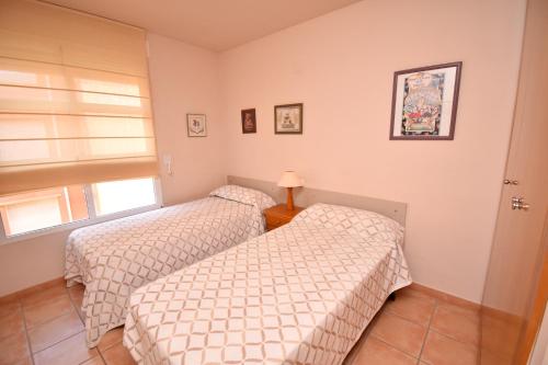 two twin beds in a room with a window at Apartamento La Senia in Jávea