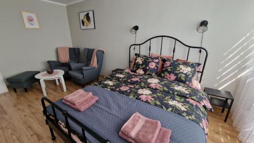 una camera con un grande letto e una sedia di Apartament SPOKO-LOKO a Stronie Śląskie