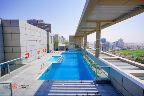 a swimming pool on the roof of a building at Alashrafia Saray, Lovely 2 BR apartment in Sport city in Dubai