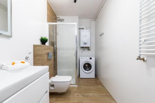 a bathroom with a toilet and a washing machine at Apartment with Parking 500 m from The Sea by Renters in Międzywodzie