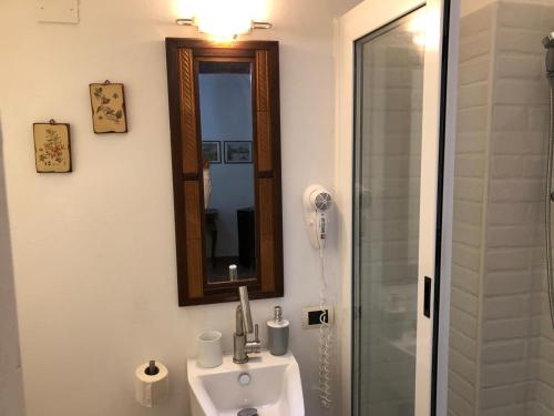 a bathroom with a sink and a mirror and a shower at Bahalara Alloggio in Palermo