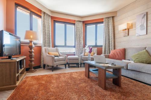a living room with a couch and a tv at Résidence Pierre & Vacances Premium L'Amara in Avoriaz