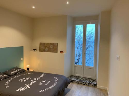 sypialnia z łóżkiem i dużym oknem w obiekcie Appartement rénové vue mer - citadelle de Bastia w Bastii