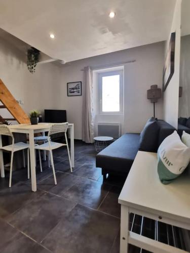 un salon avec un canapé bleu et une table dans l'établissement Esprit du Sud - Appartement cosy proche centre -, à Toulon