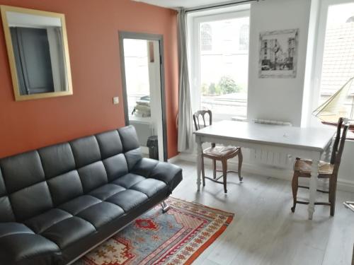 een woonkamer met een bank en een tafel bij Les Fleurs Wimille / Wimereux in Wimille