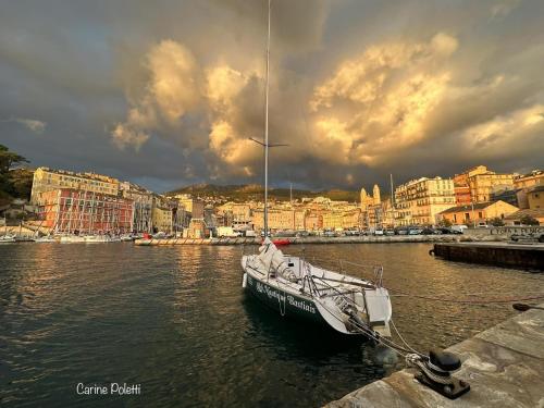 a boat is docked in the water near a city at Bastia Room in Bastia