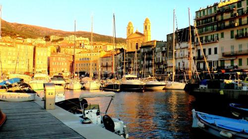 un gruppo di imbarcazioni ormeggiate in un porto con edifici di Bastia Room a Bastia