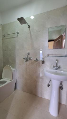 un bagno con lavandino, WC e specchio di Himalayan Hidden Treasure a Pokhara