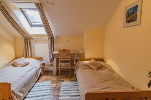 twee bedden in een kamer met een tafel en een raam bij Ferienwohnung Sigrid & Ferdinand BERGINC in Hollenstein an der Ybbs